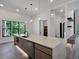 Modern kitchen featuring a large island with a marble countertop and stainless steel appliances and view of outdoor trees at 191 Darwish Dr, Mcdonough, GA 30252