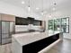 A bright kitchen features black and wood cabinetry, a large island, and stainless steel appliances at 191 Darwish Dr, Mcdonough, GA 30252