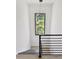 Stairwell features contemporary chandelier and large window showing verdant landscaping at 191 Darwish Dr, Mcdonough, GA 30252
