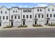 Modern townhouse exterior features a white facade, black accents, and single-car garages at 3145 Washburn Sw St, Atlanta, GA 30354