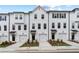 View of townhomes featuring white exterior, black door, driveway, and well-maintained landscaping at 3149 Washburn Sw St, Atlanta, GA 30354