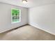 Bright bedroom with a window view of lush greenery and neutral carpeting at 45 Carroll St, Temple, GA 30179