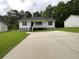 Charming single-story home with white siding, red shutters, and a spacious concrete driveway at 45 Carroll St, Temple, GA 30179