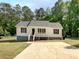 Charming single-story home with a well-maintained lawn, complemented by a concrete driveway and mature trees at 45 Carroll St, Temple, GA 30179