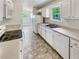 Well-equipped kitchen with white appliances and cabinetry, including a stainless steel sink at 45 Carroll St, Temple, GA 30179