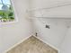 A dedicated laundry space featuring practical wire shelving and a window with a verdant view at 45 Carroll St, Temple, GA 30179