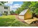 Backyard featuring a charming greenhouse and a lush green lawn for gardening and outdoor activities at 725 Crab Orchard Ct, Roswell, GA 30076