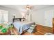 Comfortable bedroom featuring hardwood floors, a ceiling fan, and two entry doors at 725 Crab Orchard Ct, Roswell, GA 30076