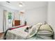 Cozy bedroom with a comfortable bed, wood floors, and a bright window with views of the outdoors at 725 Crab Orchard Ct, Roswell, GA 30076