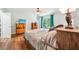 Cozy bedroom featuring hardwood floors, a ceiling fan, and views of the green outdoors at 725 Crab Orchard Ct, Roswell, GA 30076