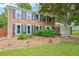 Traditional two-story brick home with a well-maintained front lawn, complemented by lush greenery and a driveway at 725 Crab Orchard Ct, Roswell, GA 30076