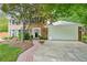 Charming brick home featuring a manicured lawn, mature trees, and an attached two-car garage at 725 Crab Orchard Ct, Roswell, GA 30076