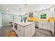 Bright, modern kitchen featuring a large island, white cabinets, stainless steel appliances, and yellow backsplash at 725 Crab Orchard Ct, Roswell, GA 30076