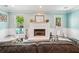 Inviting living room featuring a white brick fireplace, large windows, and light blue walls at 725 Crab Orchard Ct, Roswell, GA 30076
