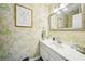 Charming powder room with floral wallpaper, white vanity, and decorative mirror at 725 Crab Orchard Ct, Roswell, GA 30076