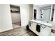 Bathroom with dual sinks, granite countertop, and a view into the walk-in closet, offering convenience and style at 11 Plymouth Ct, Kingston, GA 30145
