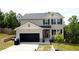 Charming two-story home with a black garage door, neutral siding, and neatly landscaped front yard at 11 Plymouth Ct, Kingston, GA 30145