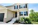 Close up of a charming two-story home entrance with a black front door and a small garden at 11 Plymouth Ct, Kingston, GA 30145