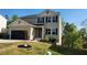 Charming two-story home with a black garage door, neutral siding, and neatly landscaped front yard at 11 Plymouth Ct, Kingston, GA 30145