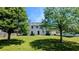 Beautiful backyard featuring green grass, mature shade trees, and the rear exterior of the home at 1395 Kala Dr, Lithonia, GA 30058