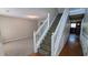 Inviting entryway showcasing a staircase with white railings and neutral-toned walls with wood and carpet flooring at 1395 Kala Dr, Lithonia, GA 30058