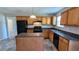 Well-equipped kitchen with an island, black appliances, wood cabinetry, and ample counter space, ready for culinary adventures at 1395 Kala Dr, Lithonia, GA 30058