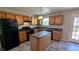 Functional kitchen featuring an island, black appliances, and wood cabinets, designed for efficient cooking at 1395 Kala Dr, Lithonia, GA 30058