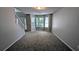 Bright living room featuring a large bay window, neutral carpet, and a staircase for upstairs access at 1395 Kala Dr, Lithonia, GA 30058