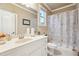 Bathroom with white cabinets, and a shower-tub with printed curtain and window at 4802 Moon Chase Dr, Buford, GA 30519