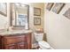 Powder room featuring vanity with granite counters, wooden cabinets, framed mirror and decor at 4802 Moon Chase Dr, Buford, GA 30519