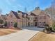 Elegant brick home boasts a three-car garage, a well-maintained lawn, and a lengthy driveway at 4802 Moon Chase Dr, Buford, GA 30519