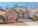 Stunning brick and stone home featuring a symmetrical facade, manicured landscaping, and a spacious driveway at 4802 Moon Chase Dr, Buford, GA 30519