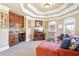 Living room showcasing a wet bar, television, red chaise lounge, and detailed trey ceiling at 4802 Moon Chase Dr, Buford, GA 30519