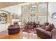 Spacious living room with high ceilings, large windows, hardwood floors, and a stone fireplace at 4802 Moon Chase Dr, Buford, GA 30519