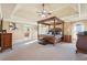 Spacious main bedroom with a four-poster bed, tray ceiling, and carpeted floor at 4802 Moon Chase Dr, Buford, GA 30519