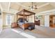 Spacious main bedroom with a four-poster bed, tray ceiling, and carpeted floor at 4802 Moon Chase Dr, Buford, GA 30519