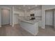 Modern kitchen showcasing a large granite island, stainless appliances, and wood floors at 490 Charleston Pl, Villa Rica, GA 30180