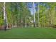 Wide shot of manicured backyard with green grass and surrounded by trees at 823 Valley Dr, Canton, GA 30114