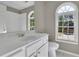 Bathroom featuring a vanity, toilet and an arched window to allow for natural light at 823 Valley Dr, Canton, GA 30114