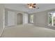 Spacious bedroom with carpeted floor, multiple doors, and windows overlooking a green landscape at 823 Valley Dr, Canton, GA 30114