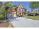 Charming home with a stone facade, a covered front porch, and a long driveway leading to an attached two-car garage at 823 Valley Dr, Canton, GA 30114