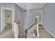 Hallway featuring a lantern, a wooden staircase with white railings and neutral-colored walls at 823 Valley Dr, Canton, GA 30114