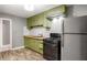 Updated kitchen featuring stainless appliances, light green cabinetry and modern white subway tile at 1290 Campbellton Sw Rd, Atlanta, GA 30310