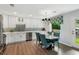 Eat-in kitchen features stainless appliances, white cabinetry, a modern light fixture, and seating for four at 2724 Saddle Ridge Lake Dr, Marietta, GA 30062