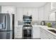 Modern kitchen boasting white cabinets, stainless steel appliances, quartz countertops, and stylish tile backsplash at 2724 Saddle Ridge Lake Dr, Marietta, GA 30062