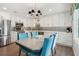 Eat-in kitchen features stainless appliances, white cabinetry, a modern light fixture, and seating for four at 2724 Saddle Ridge Lake Dr, Marietta, GA 30062