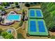 Overhead shot of a community featuring a pool, tennis courts, a playground, and green spaces at 702 Village Field Ct, Suwanee, GA 30024