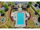 Stunning aerial view of the community pool area with chairs, cabanas, and lush landscaping at 702 Village Field Ct, Suwanee, GA 30024