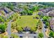 Beautiful aerial view of a neighborhood with a green common area and mature trees at 702 Village Field Ct, Suwanee, GA 30024