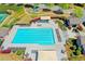 The community pool is seen from above with sun-bathing lounges, canopies, and play areas at 702 Village Field Ct, Suwanee, GA 30024